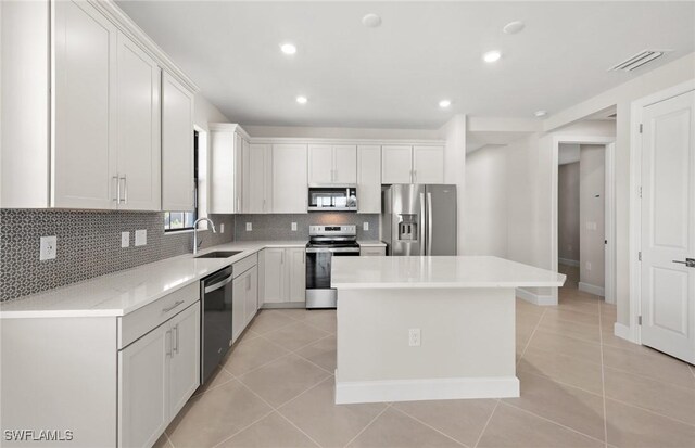 16740 Rolling Rock Blvd, Alva, FL 33920 - kitchen featuring stainless steel appliances, a sink, light tile patterned floors, decorative backsplash, and a kitchen island