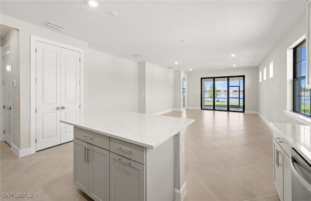 16740 Rolling Rock Blvd, Alva, FL 33920 - kitchen with stainless steel dishwasher, light tile patterned flooring, a center island, recessed lighting, and gray cabinetry