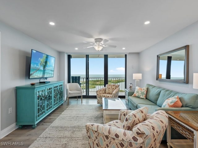 living room with baseboards, recessed lighting, a ceiling fan, and wood finished floors