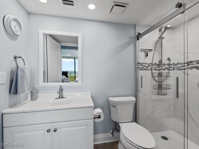 bathroom with vanity, a stall shower, toilet, and visible vents