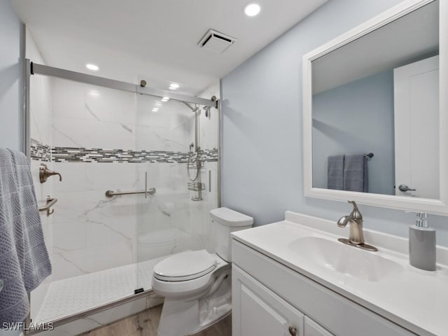 full bathroom featuring visible vents, a marble finish shower, toilet, and vanity