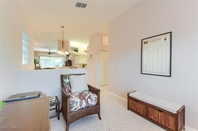 sitting room featuring a ceiling fan and baseboards