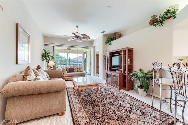 living area featuring a ceiling fan, carpet floors, and baseboards