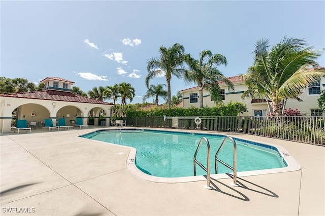 community pool featuring a patio and fence