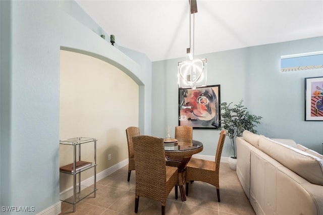 tiled dining area with arched walkways and baseboards