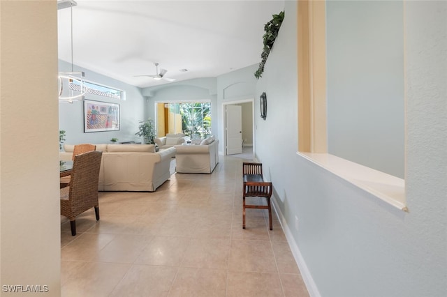 living room featuring ceiling fan, light tile patterned floors, and baseboards