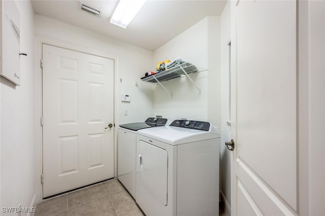 clothes washing area featuring separate washer and dryer and light tile patterned flooring