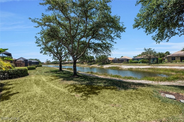 view of grassy yard featuring a water view and a residential view