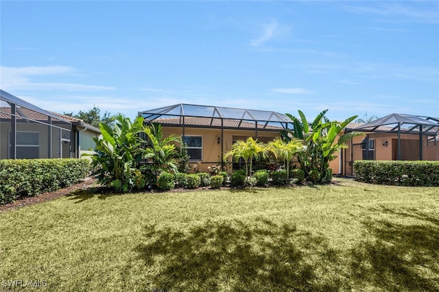 view of grassy yard featuring a lanai