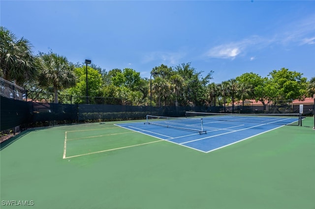 view of tennis court featuring fence and community basketball court
