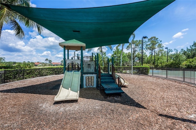 community play area featuring fence and a water view