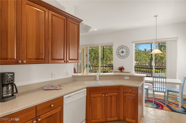 14572 Bellino Ter Unit 202, Bonita Springs, FL 34135 - kitchen with white dishwasher, brown cabinetry, a sink, a peninsula, and light countertops