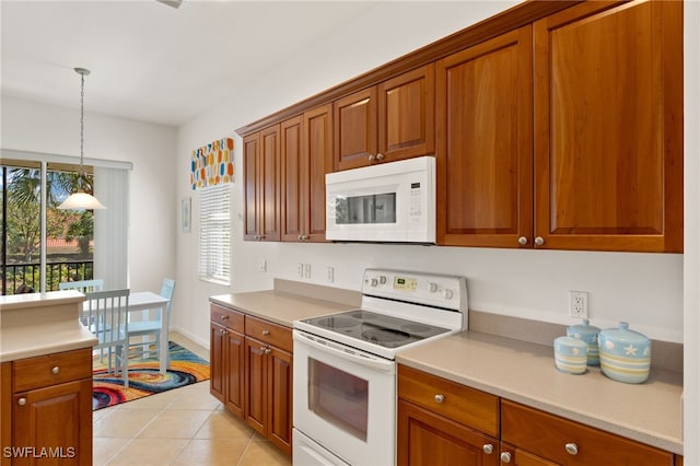 14572 Bellino Ter Unit 202, Bonita Springs, FL 34135 - kitchen with brown cabinetry, white appliances, hanging light fixtures, light tile patterned flooring, and light countertops