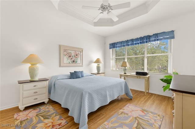 14572 Bellino Ter Unit 202, Bonita Springs, FL 34135 - bedroom featuring ornamental molding, a tray ceiling, wood finished floors, baseboards, and a ceiling fan