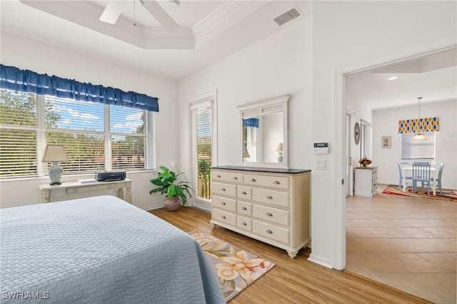 14572 Bellino Ter Unit 202, Bonita Springs, FL 34135 - bedroom featuring ornamental molding, baseboards, light wood-type flooring, a raised ceiling, and ceiling fan