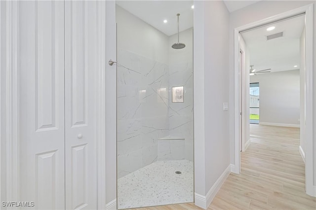 full bath with baseboards, ceiling fan, a marble finish shower, and wood finished floors