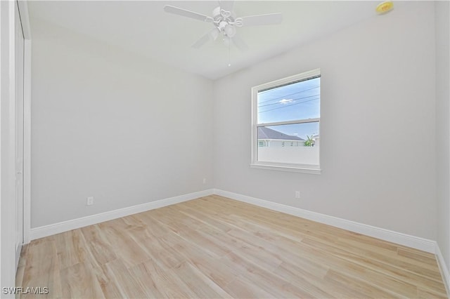 unfurnished room featuring baseboards, a ceiling fan, and light wood-style flooring