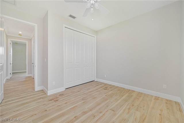 unfurnished bedroom featuring baseboards, visible vents, light wood finished floors, and a closet