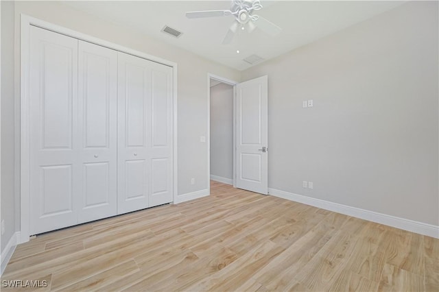 unfurnished bedroom featuring a ceiling fan, visible vents, light wood-type flooring, baseboards, and a closet