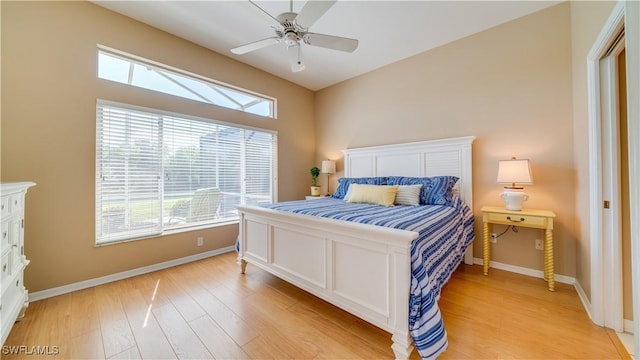 bedroom with baseboards, ceiling fan, and light wood-type flooring