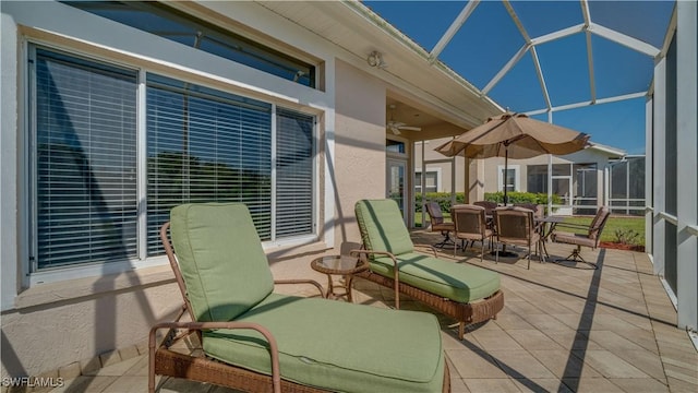 view of patio / terrace with a ceiling fan, a lanai, and outdoor dining area