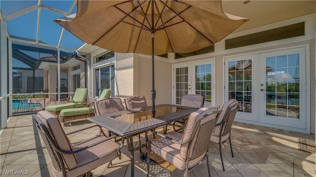 view of patio featuring outdoor dining area, glass enclosure, and french doors