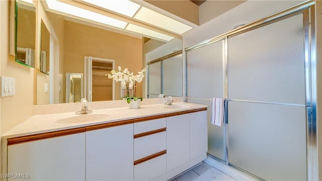 bathroom featuring a sink, a stall shower, and double vanity