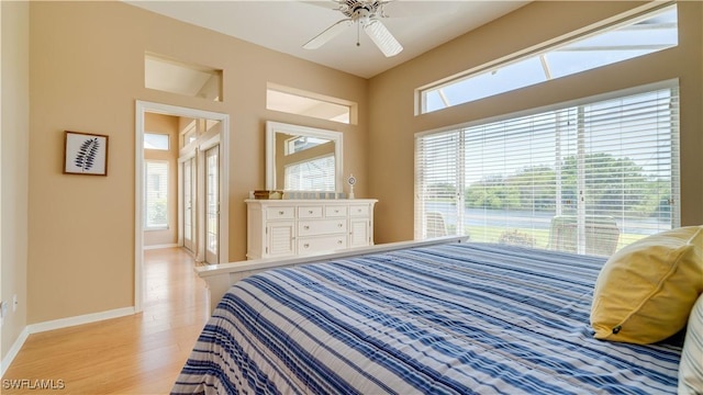 bedroom with light wood-style floors, baseboards, and a ceiling fan