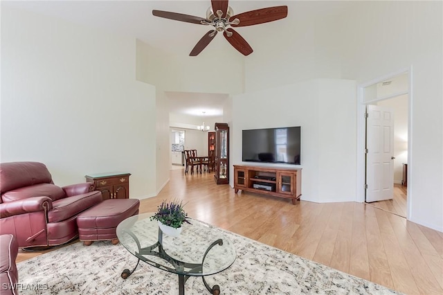 23061 Grassy Pine Dr, Estero, FL 33928 - living area featuring baseboards, a high ceiling, ceiling fan with notable chandelier, and wood finished floors