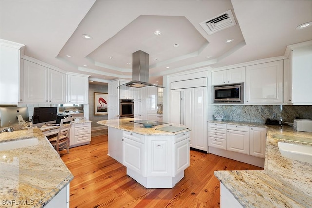 8477 Bay Colony Dr Unit 1102, Naples, FL 34108 - kitchen featuring visible vents, built in appliances, island range hood, a raised ceiling, and a sink
