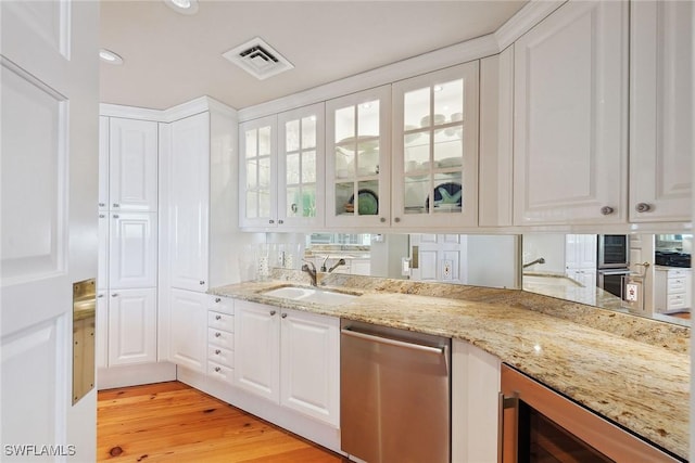 8477 Bay Colony Dr Unit 1102, Naples, FL 34108 - kitchen with a sink, white cabinetry, stainless steel dishwasher, visible vents, and glass insert cabinets