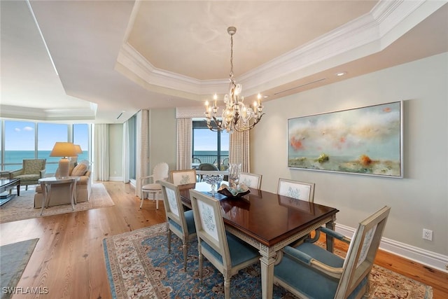 8477 Bay Colony Dr Unit 1102, Naples, FL 34108 - dining room with light wood-style floors, ornamental molding, a chandelier, and a tray ceiling