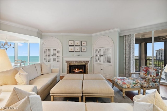 8477 Bay Colony Dr Unit 1102, Naples, FL 34108 - living room with a premium fireplace, a chandelier, wood finished floors, a water view, and ornamental molding