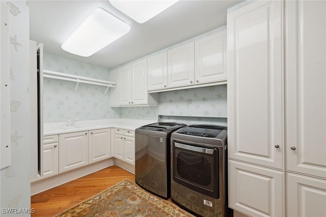 8477 Bay Colony Dr Unit 1102, Naples, FL 34108 - clothes washing area with wallpapered walls, light wood-type flooring, separate washer and dryer, a sink, and cabinet space