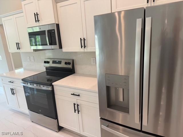 kitchen featuring light countertops, appliances with stainless steel finishes, and white cabinets