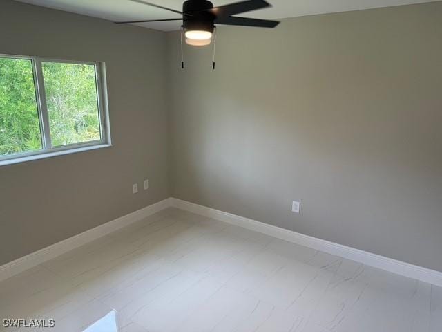 unfurnished room featuring baseboards and a ceiling fan