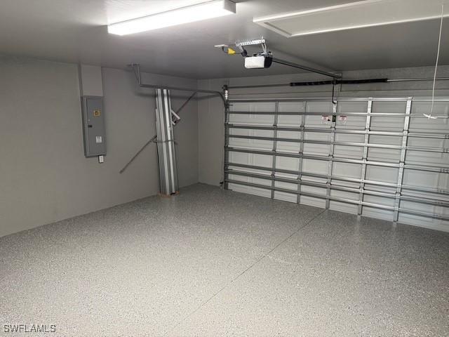 garage with a garage door opener and electric panel