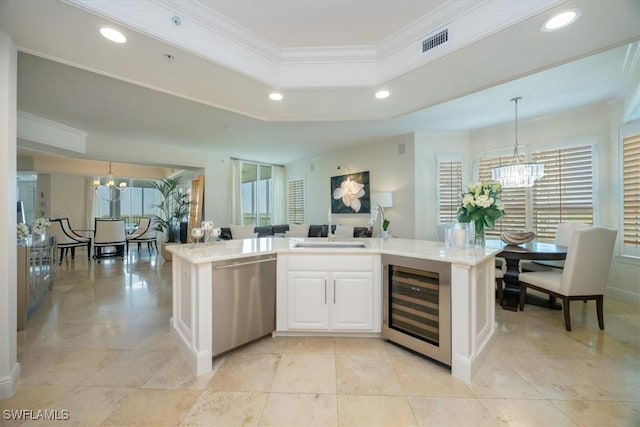 kitchen with a chandelier, stainless steel dishwasher, beverage cooler, white cabinets, and crown molding