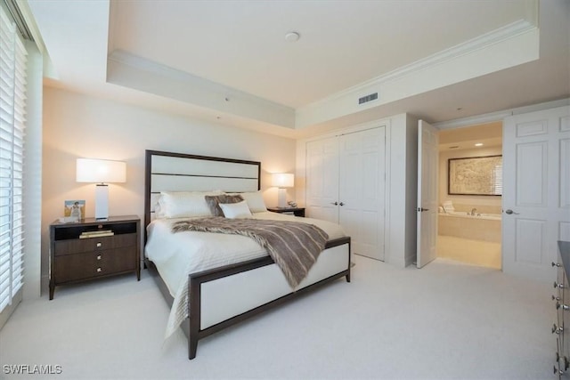 bedroom with light colored carpet, a closet, a raised ceiling, and crown molding