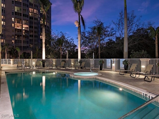 community pool with a patio, a community hot tub, and fence
