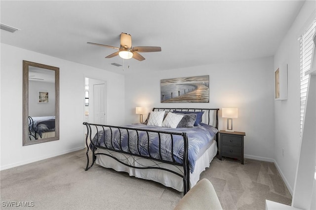 carpeted bedroom with baseboards, a ceiling fan, and visible vents