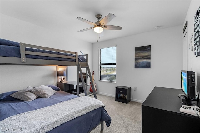 bedroom featuring light colored carpet, baseboards, and ceiling fan