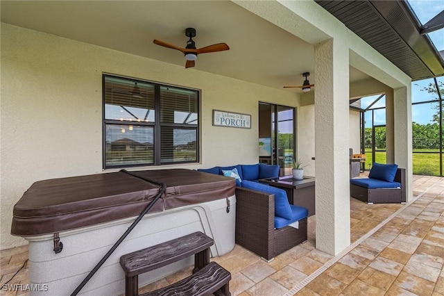 view of patio / terrace with outdoor lounge area, a hot tub, ceiling fan, and glass enclosure