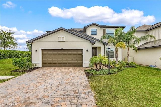 traditional-style house featuring decorative driveway, stucco siding, and a front yard
