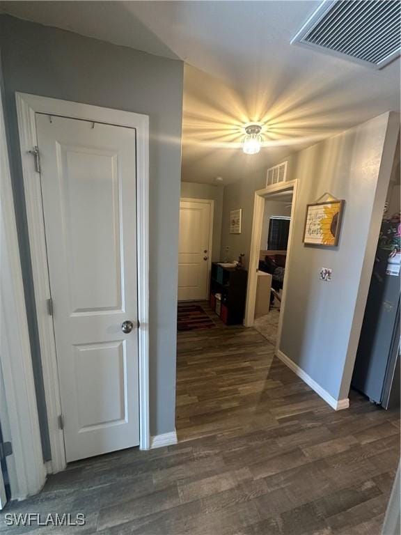 hallway with baseboards, dark wood-style floors, and visible vents
