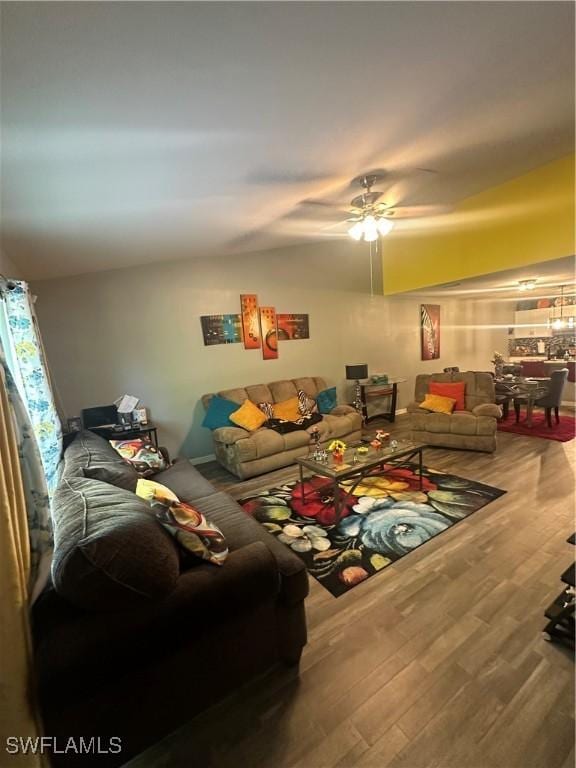 living room featuring a ceiling fan, wood finished floors, and lofted ceiling