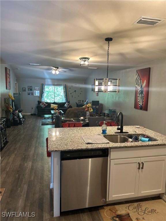 kitchen with light stone counters, white cabinetry, open floor plan, stainless steel dishwasher, and visible vents