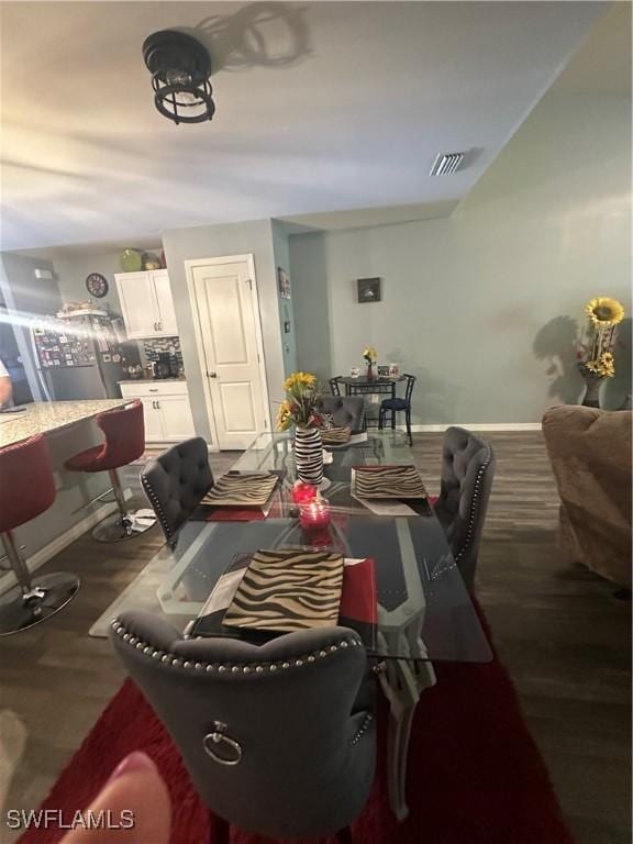 dining room featuring baseboards, wood finished floors, and visible vents