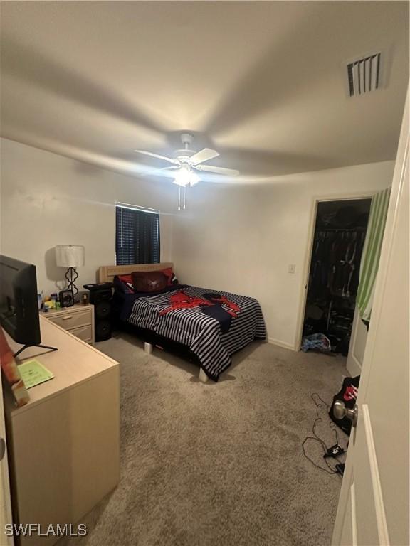 carpeted bedroom featuring visible vents and a ceiling fan