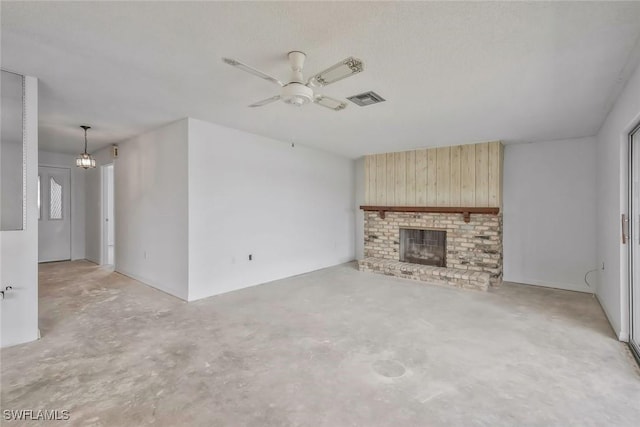 unfurnished living room featuring a brick fireplace, wood walls, a ceiling fan, visible vents, and unfinished concrete flooring